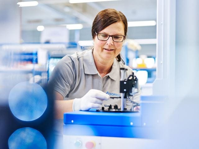 A woman working at a TRIOPTICS metrology station